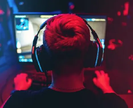 A gamer in headphones lit in red and blue