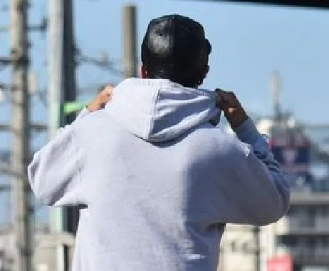 A young rider in a hoodie, from behind